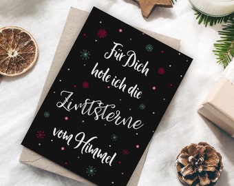 May include: Black card with white text that reads "For you I get the twinkling stars from the sky". The card is decorated with small red, green, and blue snowflakes.