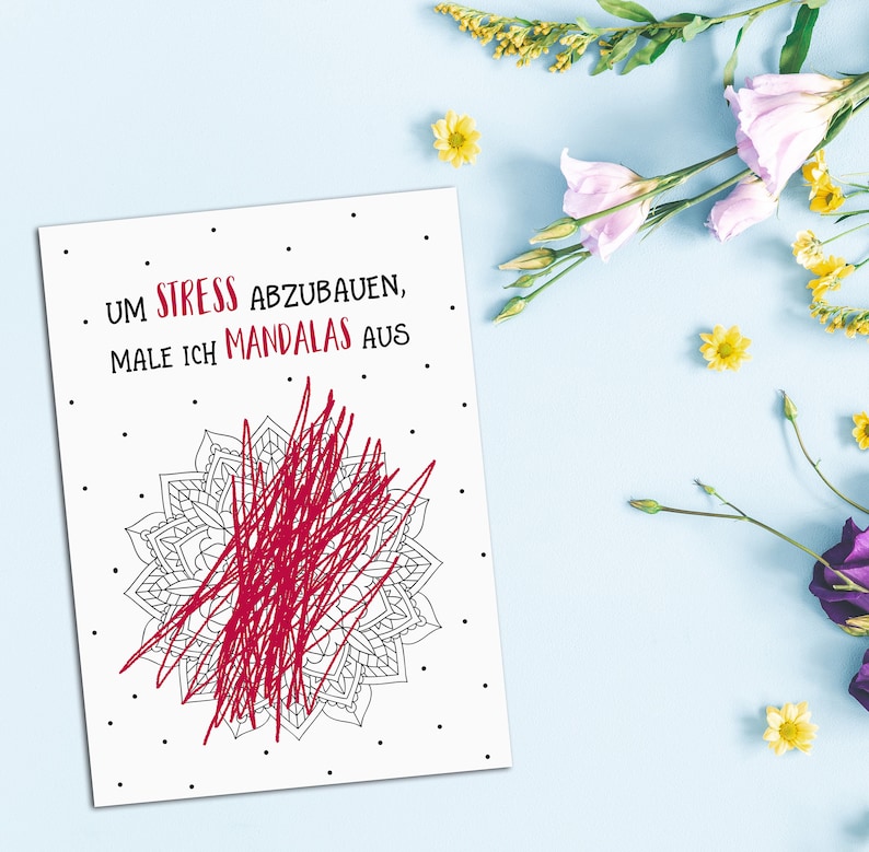 May include: A white card with black text that reads "Um Stress abzubauen, male ich Mandalas aus."  A black and white mandala is partially filled in with red scribbles.