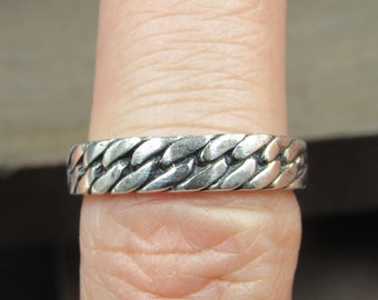 May include: A silver ring with a braided design.