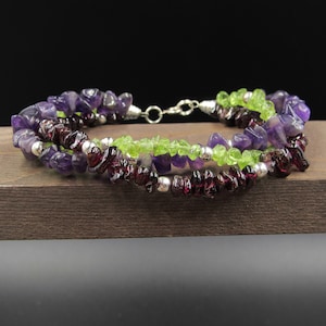 May include: A multi-strand bracelet with amethyst, peridot, and garnet beads. The bracelet is made with silver beads and a silver clasp.