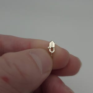 May include: Close-up of a silver lobster clasp on a chain.