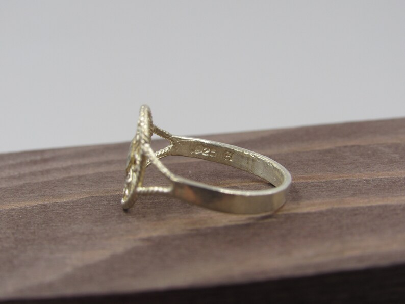 May include: Silver ring with a delicate, intricate design. The ring is marked with the number "925" on the inside band, indicating it is made of sterling silver.