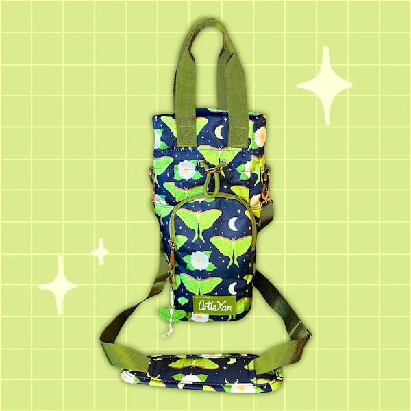 Könnte beinhalten: Eine grüne und schwarze Stofftasche mit einem Trageriemen. Die Tasche hat einen Aufdruck von grünen Motten und weißen Blumen auf schwarzem Hintergrund. Die Tasche hat einen Reißverschluss und eine kleine Tasche auf der Vorderseite. Die Tasche hat den Text "ArtieXan" auf der Vorderseite aufgedruckt.