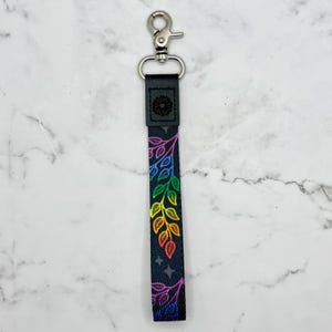 May include: A black key chain with a rainbow leaf design and a silver swivel clip.