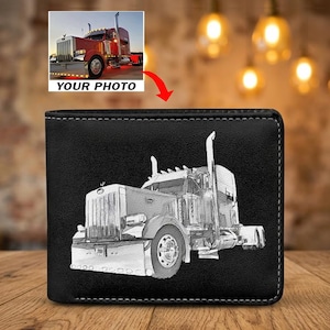 May include: Black bi-fold wallet with a detailed, grayscale illustration of a semi-truck. The wallet has white stitching around the edges. A smaller image of a red semi-truck with the text "YOUR PHOTO" is in the upper left corner.