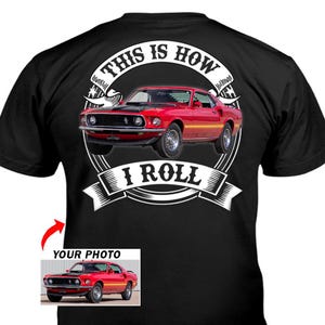 May include: Black t-shirt featuring a red classic car graphic with the text "THIS IS HOW I ROLL" in a white circular design. A smaller image of the car is in the lower left corner with the text "YOUR PHOTO".