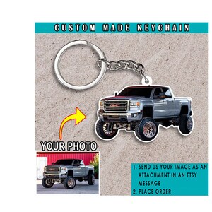May include: Custom made keychain featuring a silver pickup truck with a black grille and large wheels. The keychain is attached to a silver key ring and chain. The image includes instructions to send a photo to be used for the keychain.