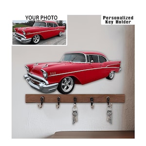 Könnte beinhalten: Ein roter Schlüsselhalter im klassischen Autodesign mit Holzsockel und fünf Haken. Der Schlüsselhalter zeigt ein rotes Oldtimer-Design und den Text "Personalized Key Holder". Schlüssel hängen an den Haken.