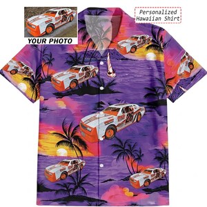 May include: A personalized Hawaiian shirt featuring a vibrant design of race cars against a sunset backdrop. The shirt showcases a repeating pattern of white and orange race cars with the number 26, palm trees, and a colorful sky. The text "Personalized Hawaiian Shirt" is visible.