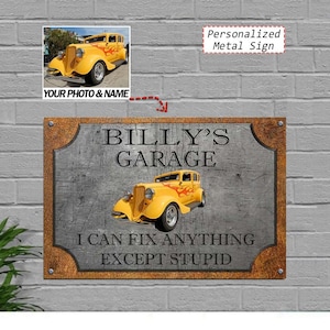 May include: A personalized metal sign with a vintage yellow car graphic and the text "BILLY'S GARAGE." The sign also includes the phrase "I CAN FIX ANYTHING EXCEPT STUPID." The sign has a brown border and is mounted on a brick wall.