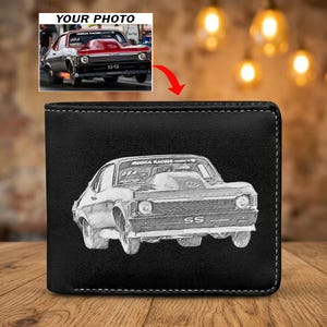 May include: Black leather wallet with a detailed grayscale sketch of a classic muscle car. The car has the letters "SS" on the front. The wallet is on a wooden surface with a blurred background of lights.