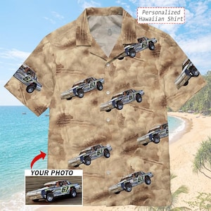 May include: A tan short-sleeve button-down shirt featuring a repeating pattern of off-road race cars with the number 67 on the sides. The fabric has a dusty, textured background print. A small inset shows a race car with the text YOUR PHOTO.