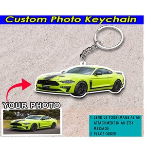May include: A custom photo keychain featuring a bright green Ford Mustang. The keychain is made of acrylic and has a silver metal key ring. The image shows a close-up of the keychain with the car in focus. The text "YOUR PHOTO" is visible in the image, indicating that the keychain can be personalized with a photo.