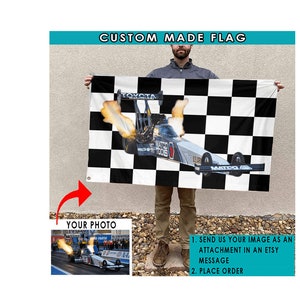 Pu&ograve; includere: Una bandiera personalizzata con uno sfondo a scacchi bianco e nero con un'auto da dragster al centro. L'auto &egrave; nera e argentata con fiamme che escono dalla parte posteriore. Il testo "MATCO TOOLS" &egrave; visibile sull'auto. La bandiera &egrave; tenuta da una persona nell'immagine.