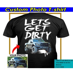 Puede incluir: Camiseta negra con texto blanco que dice "Lets Get Dirty" y una camioneta negra con un logotipo Ford blanco. El texto está escrito a mano. Hay un espacio para agregar una foto personalizada de una camioneta.