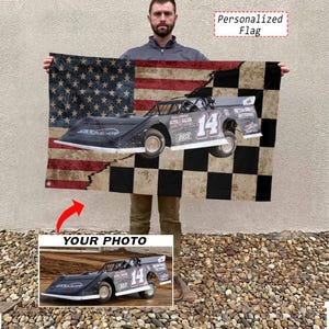 May include: A rectangular flag featuring a split design with a distressed American flag on the left and a black and white checkered pattern on the right. A black race car with the number 14 printed on the side is centered across the design.