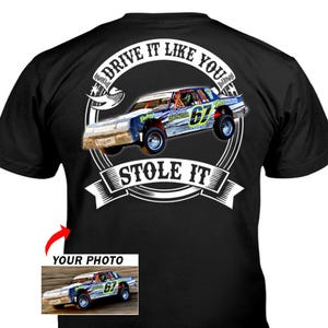 May include: Black t-shirt featuring a race car graphic with the text "DRIVE IT LIKE YOU STOLE IT." The car is blue, white, and red, with the number 67 on the side. A smaller image of the car is in the lower left corner.