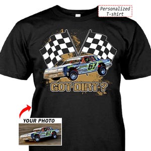 以下が含まれることがあります： 黒いTシャツ。レースカーのデザイン、チェッカーフラッグ、そして「GOT DIRT？」の文字が特徴です。デザインには、ナンバー67のレーシングカーが含まれています。シャツには「Personalized T-shirt」と「YOUR PHOTO」の文字も入っています。