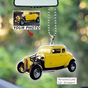 May include: A personalized car ornament featuring a yellow vintage hot rod coupe. The ornament hangs from a silver ball chain and displays a detailed graphic of the classic car. A small inset shows the same yellow car with the text YOUR PHOTO.