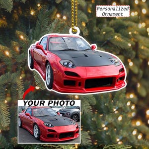 May include: A personalized ornament featuring a red sports car with a black hood. The ornament displays the text Personalized Ornament and includes a rectangular inset showing the same red sports car with the text YOUR PHOTO above it.