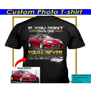 Puede incluir: Camiseta negra con el texto "Si no tienes uno, nunca lo entenderás" en letras doradas. Un coche deportivo rojo aparece en la camiseta. El texto "Tu foto" está en un rectángulo blanco con un coche deportivo rojo en el fondo. Las instrucciones para personalizar la camiseta se enumeran en el lado derecho de la imagen.