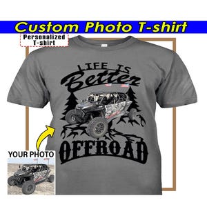 Op de afbeelding: Grijs t-shirt met een afbeelding van een off-road voertuig, de tekst "LIFE IS Better OFFROAD", en de woorden "Custom Photo T-shirt" en "Personalized T-shirt". Een kleine foto van het voertuig is ook inbegrepen.