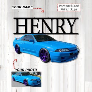 May include: Black metal sign with the name "HENRY" cut out, above a blue sports car with purple rims. The sign is personalized and includes the text "Your Name" and "Your Photo". The sign is mounted on a white wooden background.