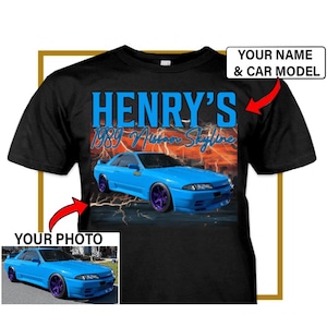 May include: Black t-shirt with a blue 1989 Nissan Skyline car graphic and the text "HENRY'S" in blue. The car is surrounded by lightning bolts and a red and orange background. The text "YOUR NAME & CAR MODEL" is in a white box with a red border. The text "YOUR PHOTO" is in a white box with a red border.