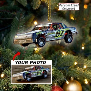 May include: A flat, custom-shaped hanging ornament featuring a race car with the number 67, sponsor decals, and the text Terminator. The ornament includes a gold hanging chain and a rectangular inset showing the original photo of the race car.