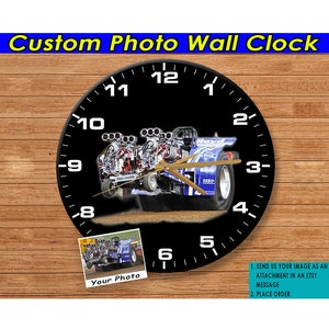 Puede incluir: Un reloj en blanco y negro con una foto personalizada de un tractor azul tirando de un trineo. La esfera del reloj tiene números negros y una aguja dorada. La foto está en un marco blanco y dice "Tu Foto". El texto "SEND US YOUR IMAGE AS AN ATTACHMENT IN AN ETSY MESSAGE 2. PLACE ORDER" está en la parte inferior de la imagen.