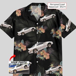 May include: Black Hawaiian shirt featuring a white sports car design, tropical flowers, and palm leaves. The shirt has a button-down front and short sleeves. The text "Personalized Hawaiian Shirt" is visible.