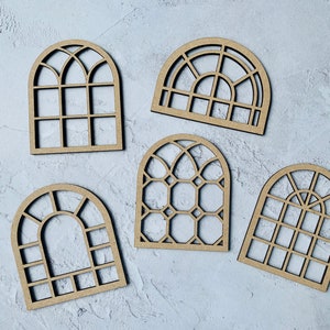 Op de afbeelding: Vijf houten boogvensterframes met verschillende ruitontwerpen. De frames zijn allemaal gemaakt van onbehandeld hout en hebben een natuurlijke bruine kleur.