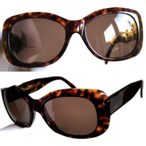 Puede incluir: Dos pares de gafas de sol con estampado de carey. Las monturas son de color marr&oacute;n oscuro con un dise&ntilde;o moteado. Las lentes son de color marr&oacute;n liso. Las gafas de sol tienen una forma rectangular cl&aacute;sica.