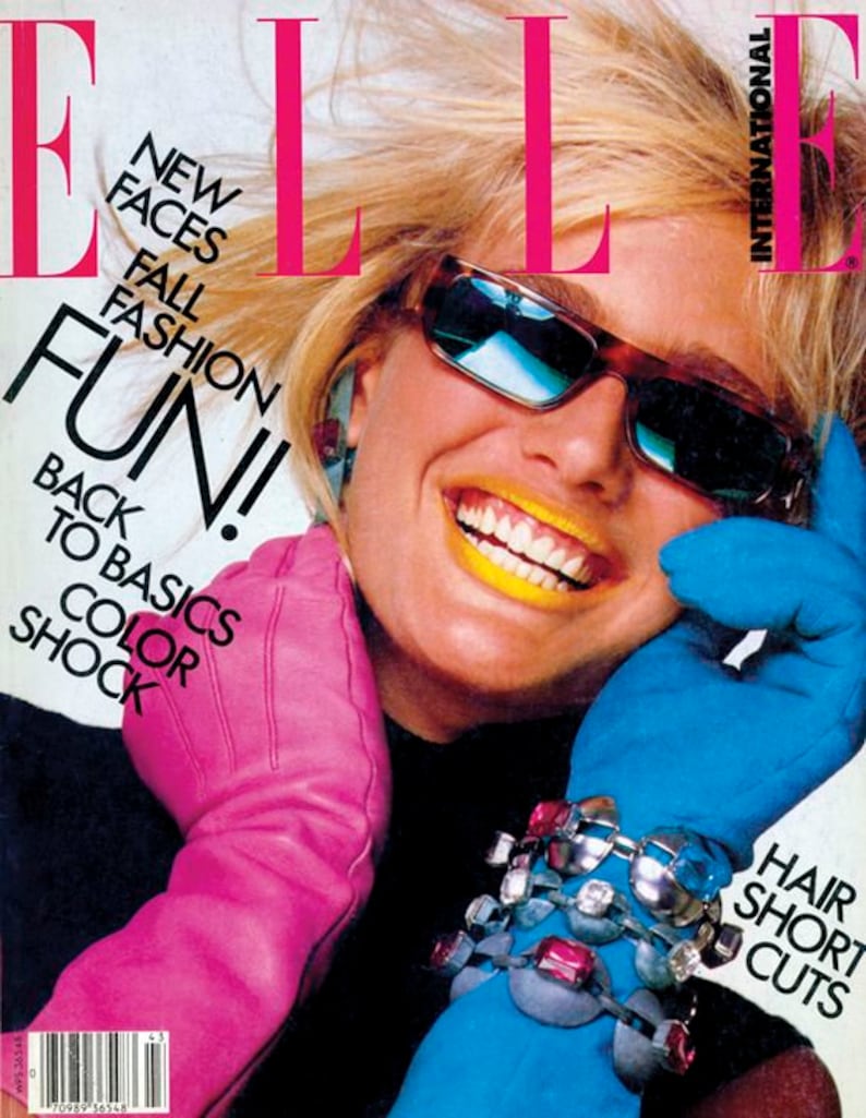 May include: A magazine cover featuring a woman wearing sunglasses and a pink glove. The magazine cover is for Elle International and features the text 'New Faces Fall Fashion Fun! Back to Basics Color Shock' and 'Hair Short Cuts'.