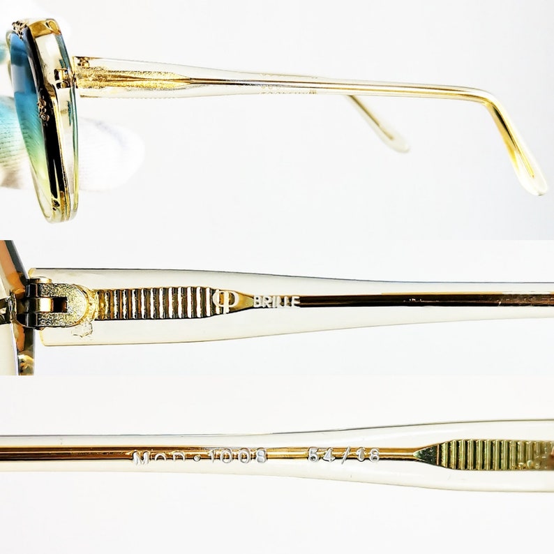 May include: Close-up of vintage gold-rimmed sunglasses with gradient blue and green lenses. The temples are clear with gold accents and the text "KP BRILLE" is visible. The frame size is 54/16.