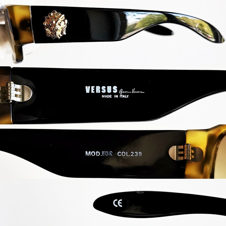 May include: Black and brown sunglasses with gold accents. The sunglasses feature a Versace logo and the text 'VERSUS Gianni Versace MADE IN ITALY' on the side. The sunglasses also have the text 'MOD. 8008 COL.239' and 'CE' on the arms.