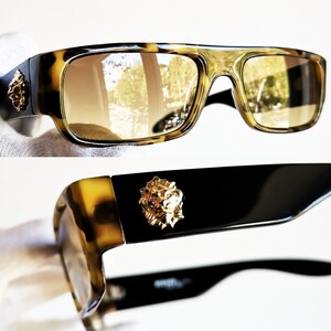 May include: Tortoiseshell sunglasses with brown lenses and a gold lion head detail on the side. 