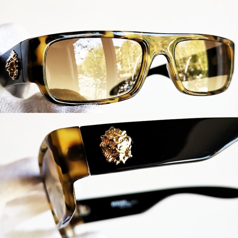 May include: Tortoiseshell sunglasses with brown lenses and a gold lion head detail on the side. 