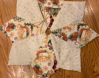 May include: A white Christmas tree skirt with a starburst design. The skirt is made of fabric with a gold glitter pattern and features a variety of Christmas-themed prints, including Santa Claus, presents, and candy canes.