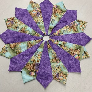 May include: Purple and green fabric Easter tree skirt with a bunny and egg design.