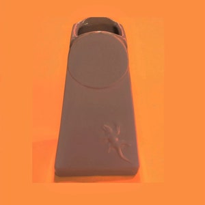 May include: A light gray ceramic vase with a round opening and a lizard design. The vase is shaped like a tall, narrow rectangle.