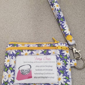 Monedero con llavero y estampado de margaritas en color morado muy bonito