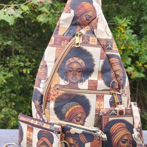 May include: A teardrop-shaped sling backpack and three matching small pouches featuring a repeating print of Black women with afro hairstyles and headwraps. The fabric has a cream, brown, and tan geometric pattern with gold-tone metal zippers.