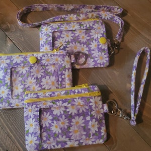 Monedero, llavero y pulsera con cordón con estampado de margaritas en color violeta claro muy bonito