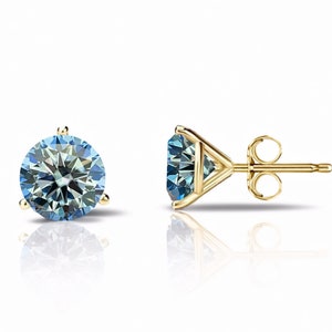 Puede incluir: Un par de pendientes de oro con una piedra redonda azul en cada pendiente.
