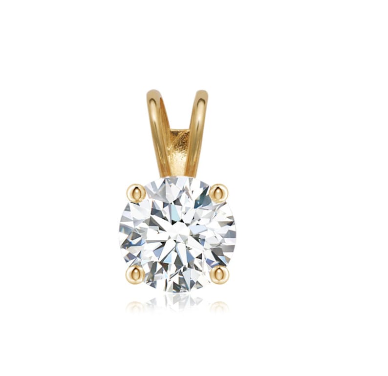 May include: A gold pendant featuring a round, clear diamond.