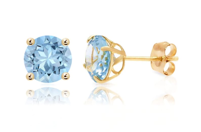 May include: A pair of gold earrings with round blue topaz gemstones. The earrings have a simple post back.