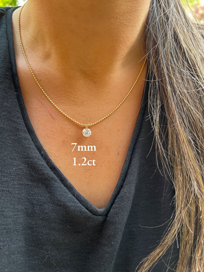 May include: A gold chain necklace with a 7mm, 1.2 carat round diamond pendant.