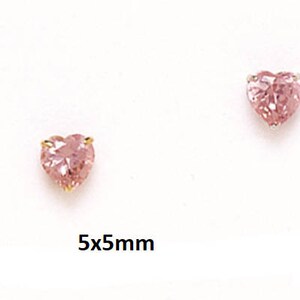 May include: Three pairs of pink heart-shaped earrings with gold settings. The earrings are 5mm x 5mm.
