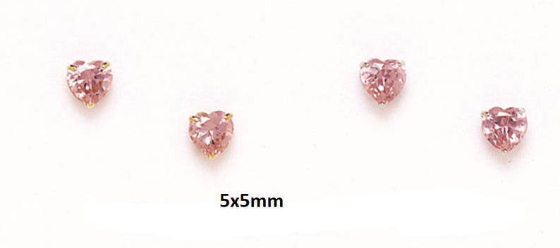 May include: Three pairs of pink heart-shaped earrings with gold settings. The earrings are 5mm x 5mm.